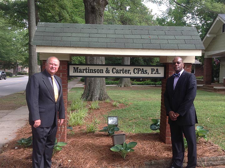 Martinson & Carter, CPAs, PA | Chris and Marty outside of their office in front of their business sign