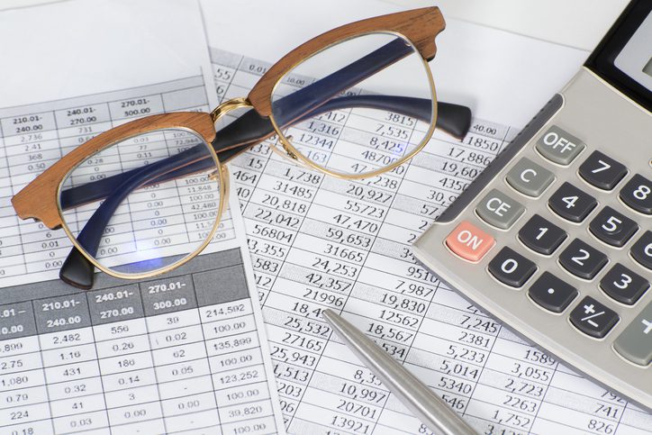 Martinson & Carter, CPAs, PA | glasses sitting on top of tax documents and laying next to a calculator and pen